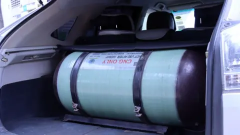 A large gas cylinder inside the trunk of the car.