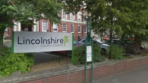 The outside of county hall in Lincoln. There is a whiteboard in front reading: Lincolnshire County Council.