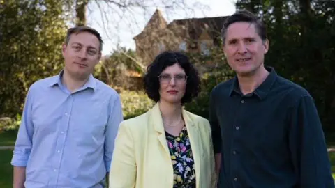 Olly Glover Olly Glover, Layla Moran and Charlie Maynard are all dressed smartly and stood next to one another whilst outside.