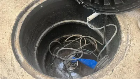 Andrew Turner/BBC Submersible pump in sump hole