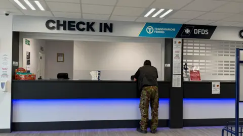 A person leans across a counter. 