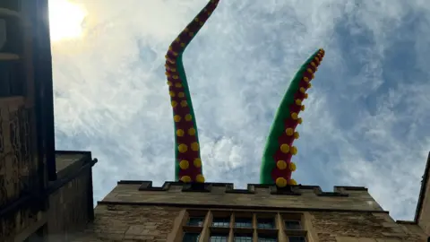  Emma Baugh/BBC An inflatable tentacle on the top of Peterborough Cathedral 