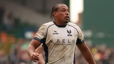 Gabriel Oghre (left) standing on the pitch during in a match