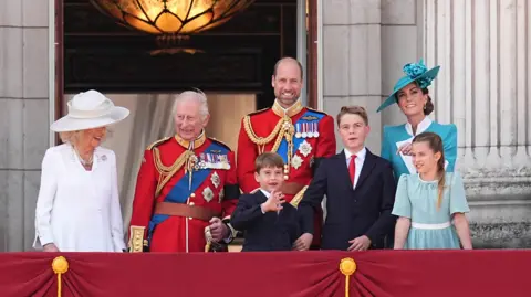 The Royal Family - including King Charles, Queen Camilla, the Prince and Princess of Wales and their three children -  stand on the Buckingham Palace balcony to watch the RAF flypast