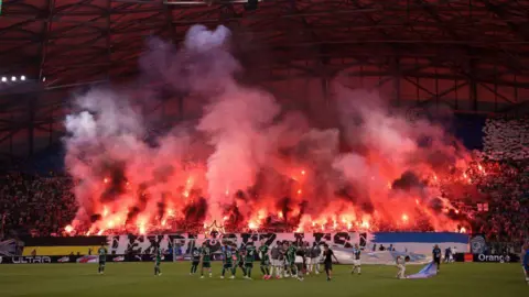 Getty Images Marseille fans light flares against Panathinaikos FC 
