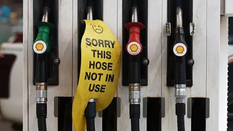 Getty Petrol dispensers at a petrol station. One has a sign reading "sorry this hose is not in use".