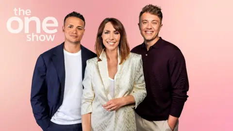 PA MEDIA Jermaine Jenas, Alex Jones y Roman Kemp sonríen mientras están parados frente a la cámara sobre un fondo color melocotón con la marca One Show.