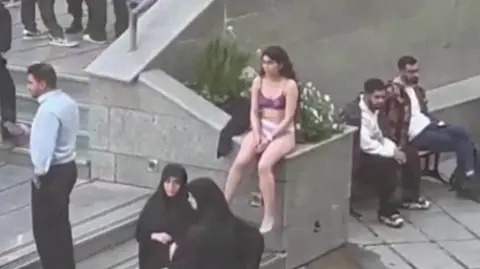 Telegram Screengrab of a video showing an Iranian woman sitting in her underwear at the Science and Research Branch of Islamic Azad University in Tehran, Iran