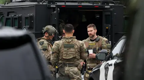 Officers work in a staging area after what police said was a targeted shooting against two Minnesota lawmakers.