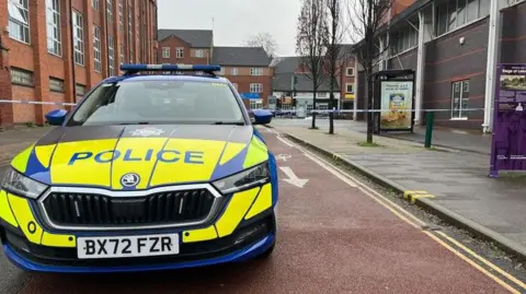 Police car in front of cordon.
