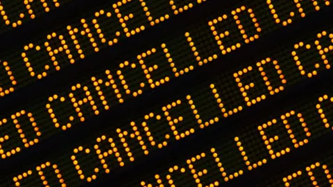 A black and orange digital sign reading cancelled multiple times. 