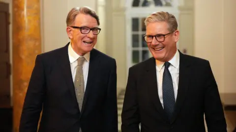 Getty Images Lord Mandelson and Sir Keir walking along a corridor entering a reception at the US ambassador's residence.