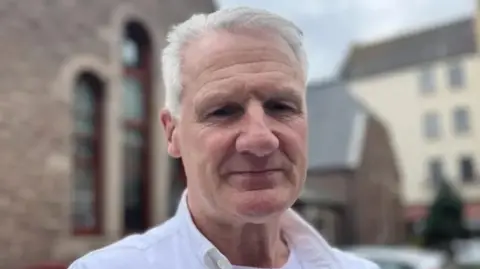 BBC Deputy Tom Binet looking into the camera