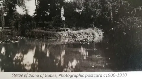 Shuttleworth Trust An old black and white picture of a statue on an island surrounded by water.