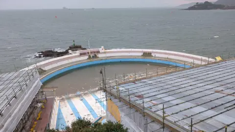 Tinside Lido looking run down and under construction with scaffolding covering the buildings. 