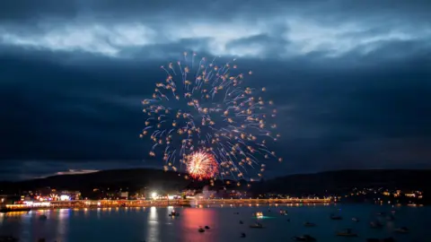 Nadine Hudson-Featherstone Fireworks in the night sky about the sea.