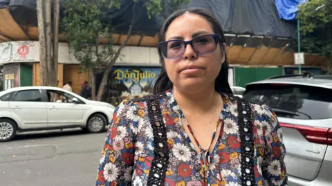 Erika Aguilar is outside the building of the apartment where he lived on a street in the central city of Mexico