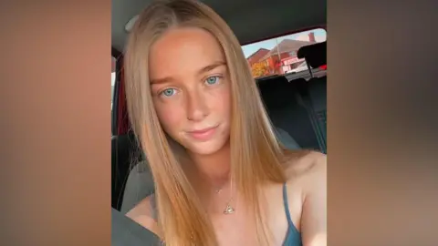 A woman with long brown hair.