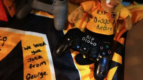 Wolves A display of a Wolves shirt, soft toys, games consoles with the words RIP Diogo written in pen