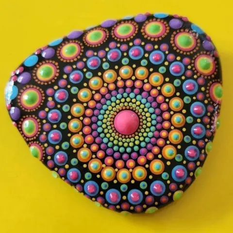 Dawn Moody A small rock is painted with multicoloured dots in circular patterns.