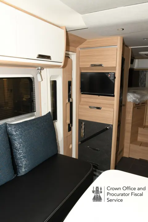 COPFS Interior of a motorhome showing seating area and media setup