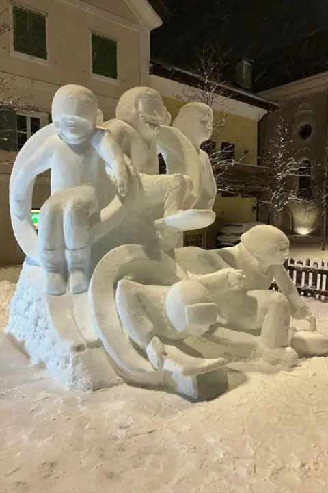 Pippa Unwin and GB Snow Sculpting team A view of the sculpture showing the front and the side. It shows the five athletes bursting through the rings. 