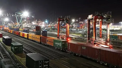 Freight trains parked back to back along a rail line in Southampton at night