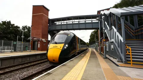 GWR A GWR train standing at the platform of the new Ashley Hill station. The pedestrian walkway over the tracks and the new platforms are also in shot