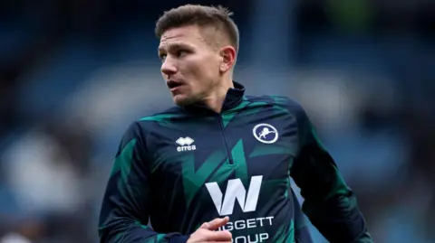 Millwall defender Shaun Hutchinson warms up