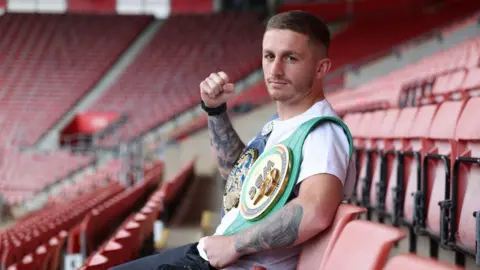 Ryan Garner poses for a photo while sat in St Mary's Stadium