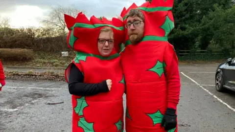 A man and a woman dressed as Christmas crackers