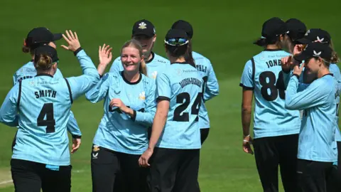 Surrey players congratulate Ryana McDonald-Gay (centre) in an earlier match this summer  