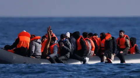 Getty Images Migrants on a small inflatable boat in the English Channel. 