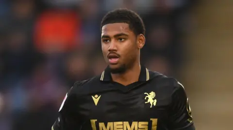 Travis Akomeah running on the pitch during a game for Gillingham