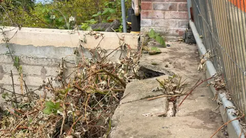 Slabs in a garden being ripped away due to a land slippage in Ansty.