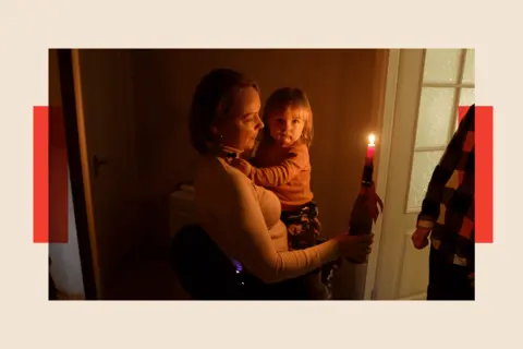 Xavier Vanpevenaege/BBC Oksana Zinkovska-Boyarska carries her young child and a candle