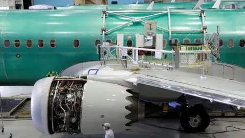 Reuters A Boeing 737 MAX aircraft being assembled at the company’s plant in Renton, Washington. A workers walks past one of the engines which is partially exposed with wiring showing.