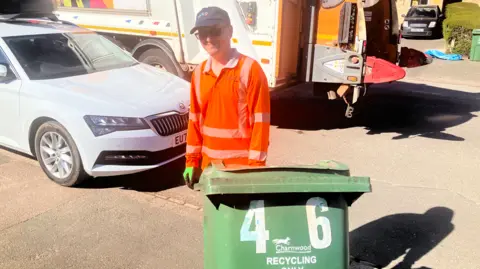 Robert Butler at work - holding a wheelie bin