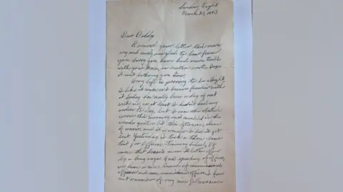 Andy Garner A letter written in a flowing script in blue ink on pale brown paper. It is addressed to Dear Daddy and dated 21 March 1943, written by Earl Thurman to his father, describing his life in the US army.