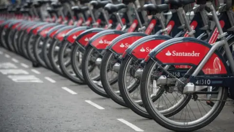 A row of bikes with Santander branding at docking stations