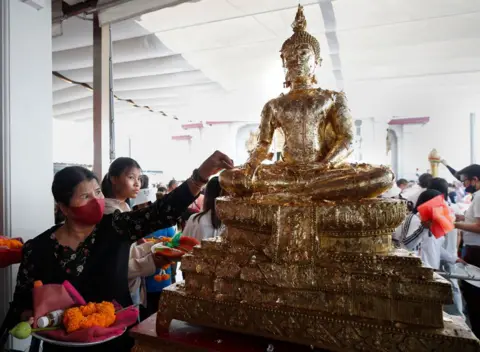 RUNGROJ YONGRIT/EPA Umat ​​Buddha Thailand berkumpul untuk menandai Tahun Baru di Kuil Pilar Kota di Bangkok, Thailand, 31 Desember 2024. 