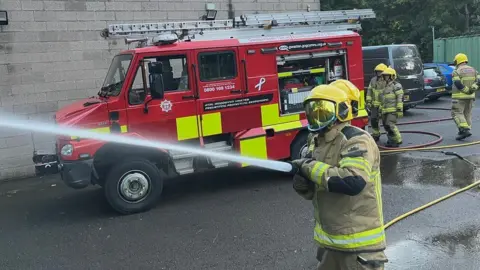 Firefighters spraying a hose