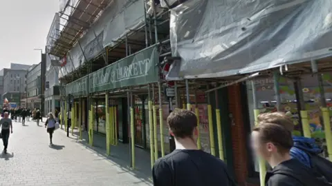 Google Image shows scaffolding surrounding the outside of a Holland & Barrett store in Liverpool. It is on a pedestrianised area in the city centre. 