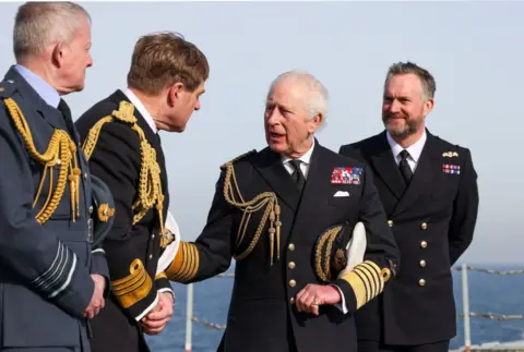 Getty, the king of the black military uniform and three people with other men in military uniforms, taking pictures by holding a lid.