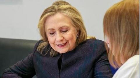 Hillary Clinton and Margaret Hedley at a desk looking at a family tree