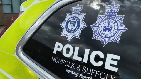 Ben Parker/BBC Close up of a Norfolk and Suffolk Police car. On the window of the car it says, Police, Norfolk and Suffolk working together.