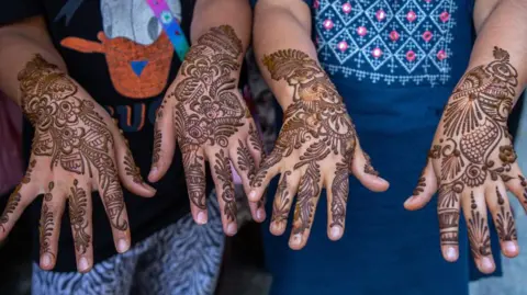 Getty Images Girls showing off their henna