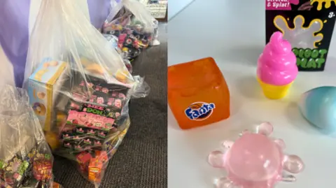 On the right is some rubber squishy toys of various designs, including an ice cream and a Fanta cube. On the lest are bags with lots of the toys piled inside.