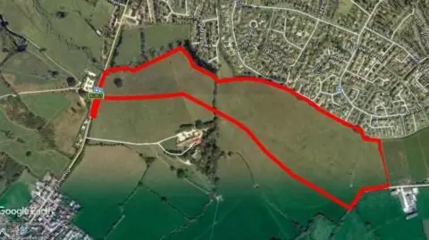 Satellite image of fields surrounding the Southwick area with a thick red line around the field earmarked for development - or a village green.