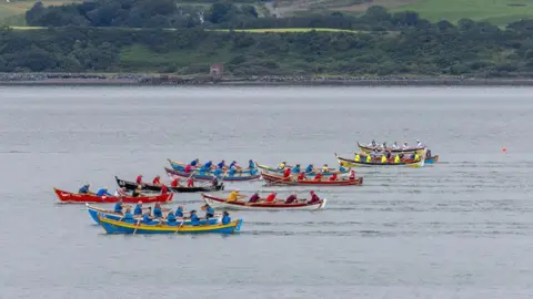 Colin Tennant A number of colourful boats race across Loch Ryan in the south of Scotland